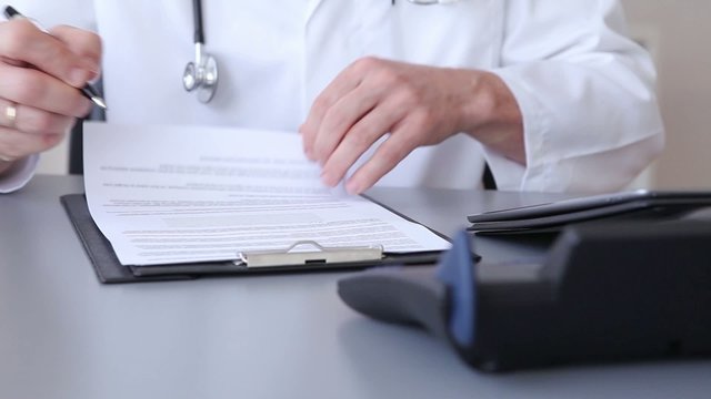 Doctor writing patient notes on a medical examination form 