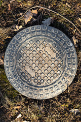 Sewer manhole cover in the park ground