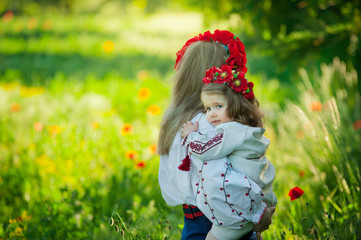 Mom and daughter in traditional Ukrainian costume in the forest