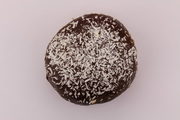 Single chocolate donut with sprinkled coconut pieces