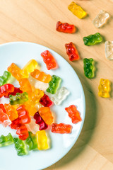gummy bears on a white plate and wooden table