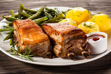 Grilled ribs, boiled potatoes and vegetables