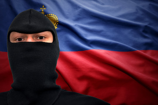 Portrait of man in mask against Liechtenstein flag