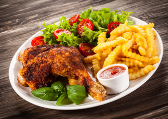 Grilled chicken leg with chips and vegetables