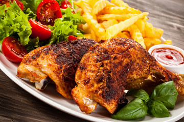 Grilled chicken leg with chips and vegetables