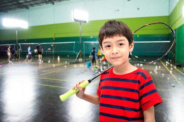 Little boy taking badminton racket in training class at the gym - obrazy, fototapety, plakaty