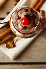 Tasty tiramisu dessert in glass, on wooden background