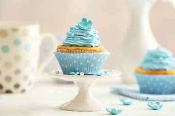 Delicious cupcakes on table on light background