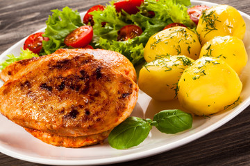 Fried chicken fillet, boiled potatoes and vegetable salad
