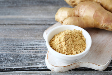 Fresh ginger root with a spicy powder in bowl