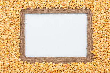 Frame made of burlap with the line and  grain pea  lies on white