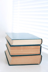 Books on white windowsill, close up