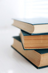 Books on white windowsill, close up