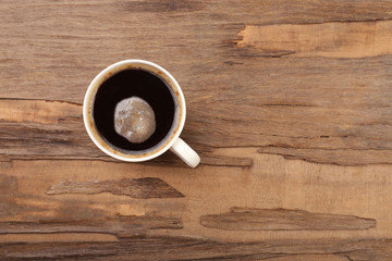 Cup of coffee on wooden table, top view