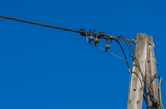Strommasten mit Stromleitung vor blauem Himmel