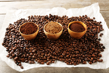 Coffee beans on crumpled parchment on wooden table, closeup