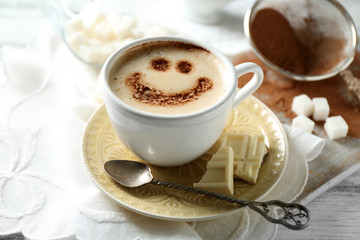 Cup of latte coffee art on wooden table, on light background