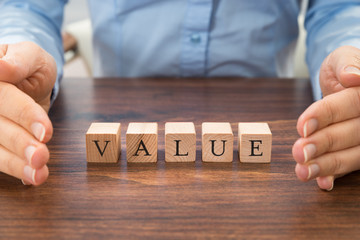 Businessperson With Value Word On Blocks