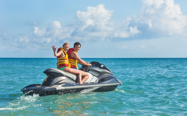 girl and young man drive on scooter