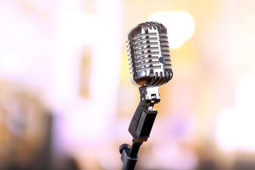 Retro microphone on bright blurred background