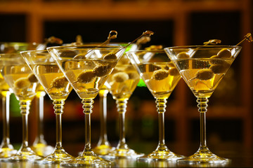 Glasses of cocktails on bar background