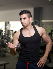 Young man training triceps muscle at gym