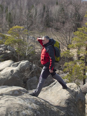 A man stands on a mountain and looking into the distance.