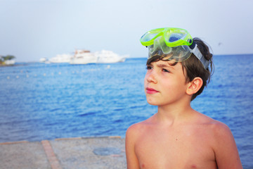 preteen handsome boy swimming on the red sea beach and yaht back