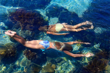 Naklejka na ściany i meble two girls swimming under water