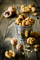 Walnut kernels and whole walnuts on wooden table