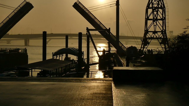 Slow motion sunset silhouette of people on the boardwalk.
