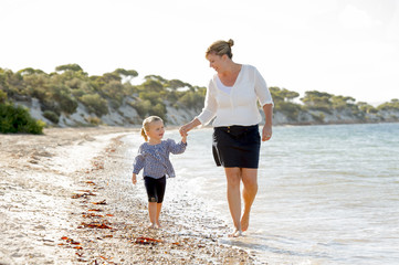 happy mother and sweet daughter walking on sand beach sea shore