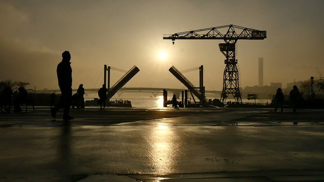 Slow motion sunset silhouette of people on the boardwalk.