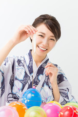 浴衣でヨーヨー釣りをする女性