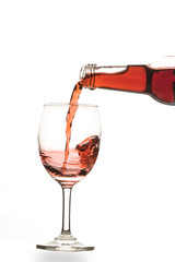 Red wine poured into glass isolated on white
