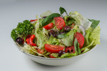 Bowl of salad with fresh vegetables on white backgroound