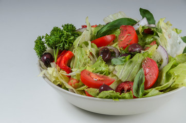 Bowl of salad with fresh vegetables on white backgroound