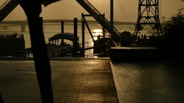 Slow motion sunset silhouette of people on the boardwalk.