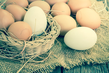 Close up of white fresh egg on basket with brown burlap