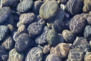 Fototapeta na wymiar Pebbles in Stream with Ripples Useful for Background or Texture