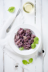 Baby octopuses with vegetable oil and green basil, above view