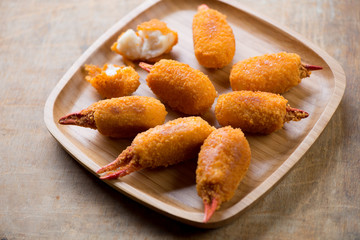 Bamboo tray with breaded crab claws, selective focus, close-up
