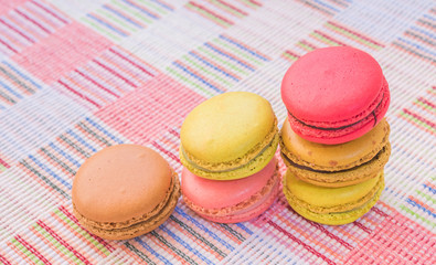 Sweet and colourful french macaroons on cotton cloth background.