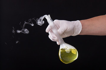 Chemical reaction in volumetric flask glass kept in the hands of