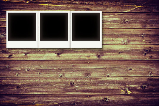 Photo frames on vintage wooden board background texture