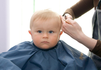 Serious 1-year boy during his first haircutting - 81753874