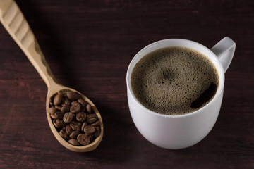 hot Cup of French coffee on wooden table and spoon full beans