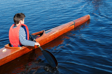 The boy rowing in a kayak on the river