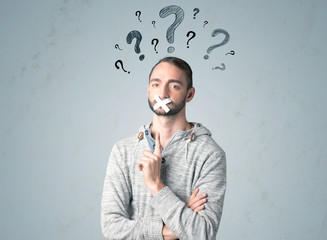 Young man with glued mouth and question mark symbols