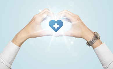 Fototapeta premium Hands creating a form with heart blue cross